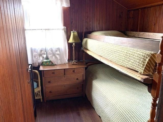 114 Long Bch, Rockport, MA 01966 - bedroom featuring wood walls and dark wood-type flooring