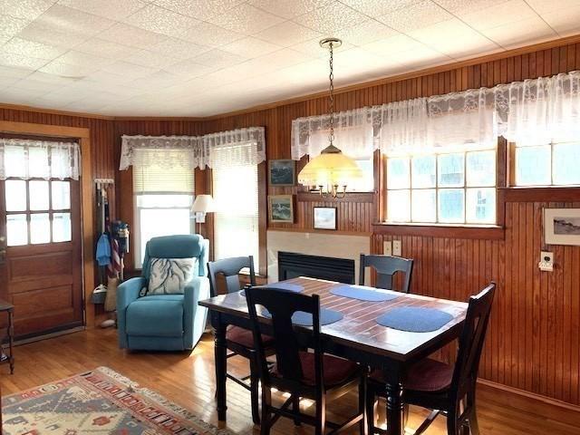 114 Long Bch, Rockport, MA 01966 - dining space featuring wood walls, wood finished floors, and a chandelier
