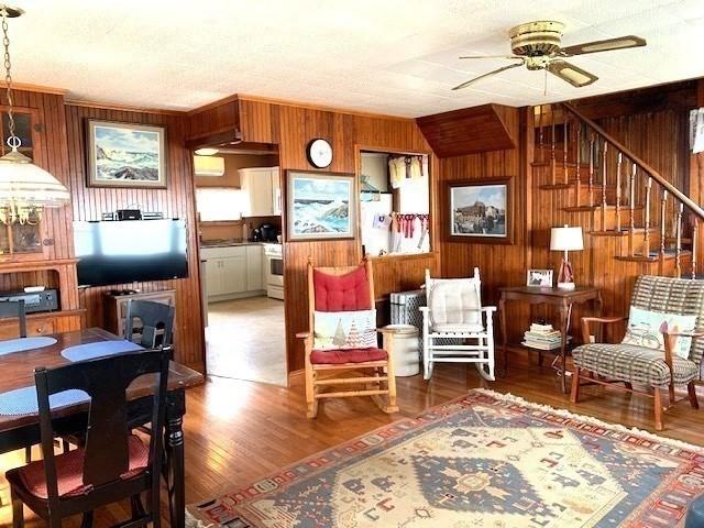 114 Long Bch, Rockport, MA 01966 - living area with ceiling fan, wooden walls, wood finished floors, and stairway