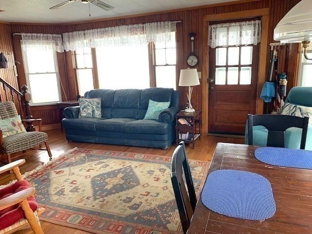114 Long Bch, Rockport, MA 01966 - living area featuring a ceiling fan, plenty of natural light, wood walls, wood finished floors, and a wall unit AC