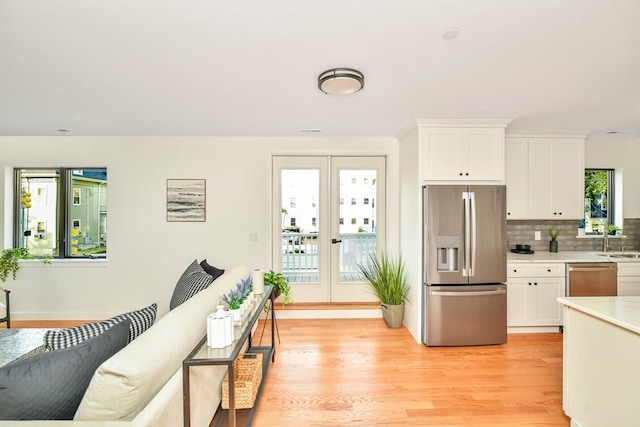 kitchen featuring light hardwood / wood-style flooring, french doors, a healthy amount of sunlight, and stainless steel appliances