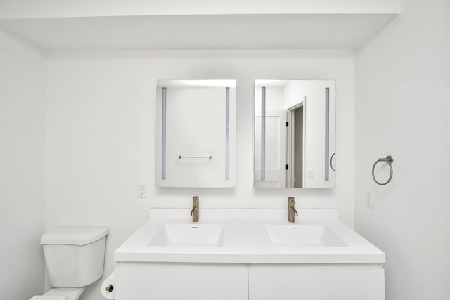 bathroom with double vanity and toilet