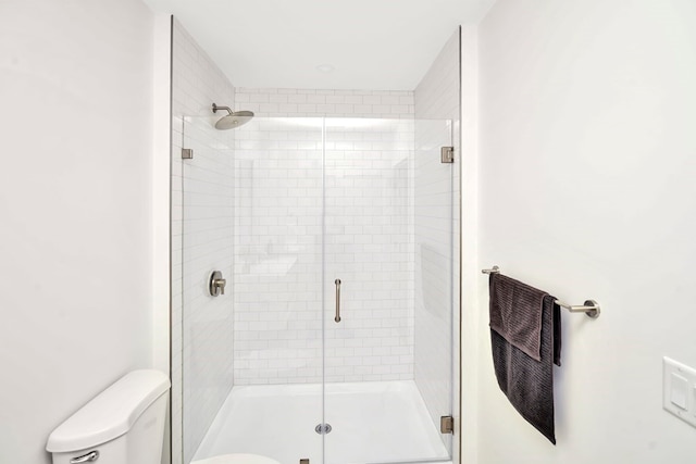 bathroom with toilet and an enclosed shower