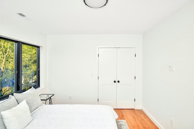 bedroom with a closet and light hardwood / wood-style floors