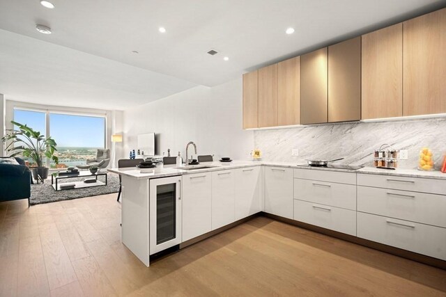 240 Devonshire St Unit 4003, Boston, MA 02110 - kitchen featuring beverage cooler, open floor plan, a peninsula, modern cabinets, and light wood-type flooring