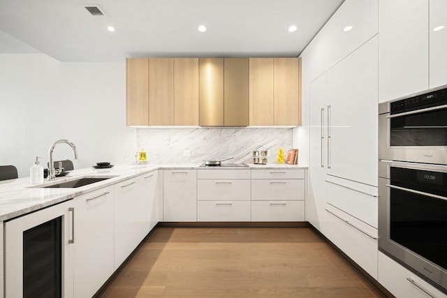 240 Devonshire St Unit 4003, Boston, MA 02110 - kitchen with wine cooler, modern cabinets, light stone counters, light wood-style floors, and double oven