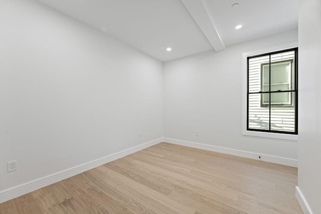 unfurnished room featuring beam ceiling and light hardwood / wood-style floors