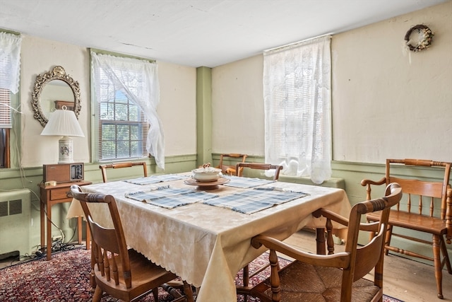 dining area featuring wood-type flooring and radiator