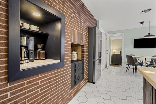 hall featuring brick wall and tile patterned flooring