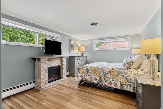 bedroom with baseboard heating, wood finished floors, ornamental molding, and a fireplace