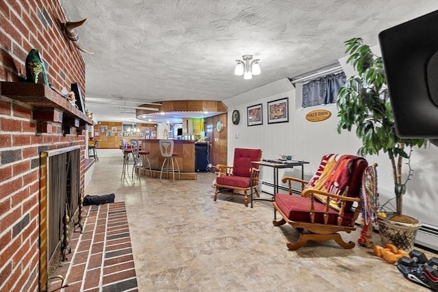 sitting room with a baseboard heating unit, a bar, and a fireplace
