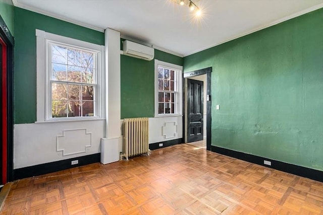 unfurnished room featuring crown molding, light parquet flooring, radiator heating unit, and a wall mounted AC