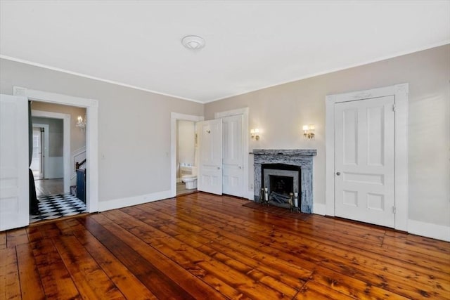 unfurnished living room with hardwood / wood-style flooring, a high end fireplace, and ornamental molding