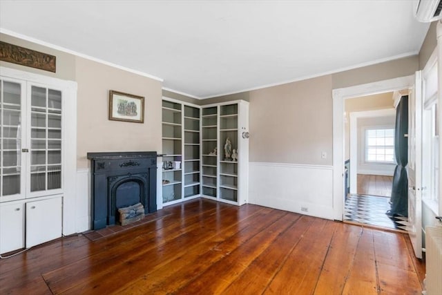 unfurnished living room featuring ornamental molding, dark hardwood / wood-style flooring, and a wall mounted air conditioner