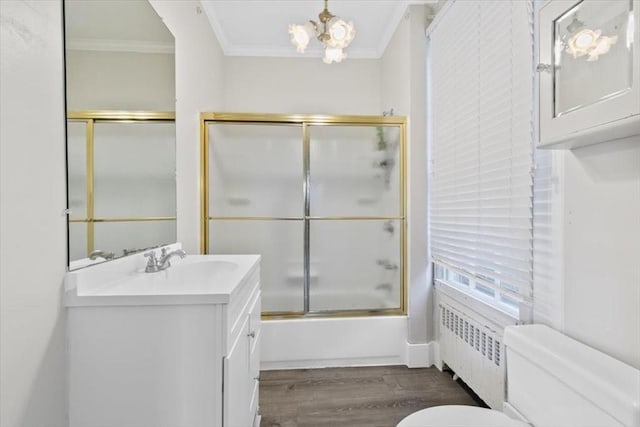 full bathroom featuring crown molding, radiator heating unit, combined bath / shower with glass door, and toilet