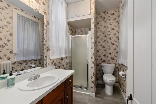 bathroom featuring vanity, toilet, radiator heating unit, and walk in shower