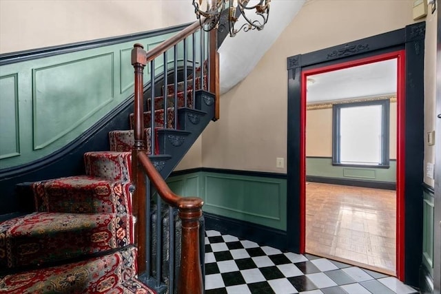 stairway with lofted ceiling and a chandelier