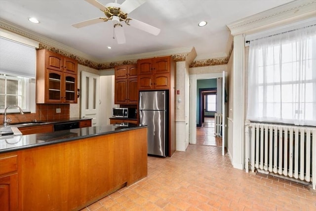 kitchen featuring crown molding, appliances with stainless steel finishes, radiator, and sink