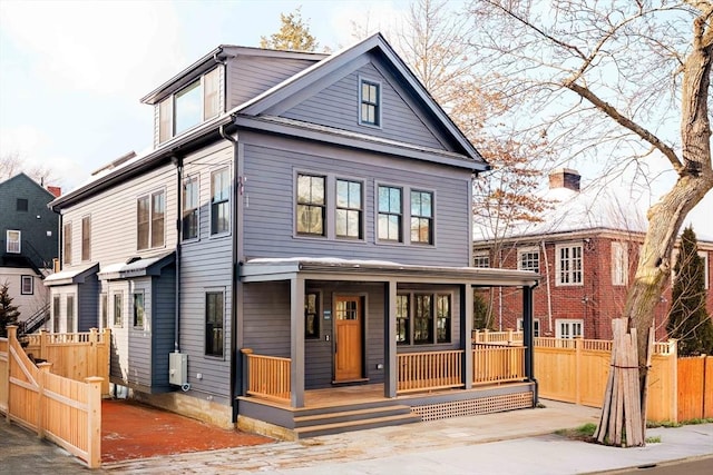 view of front facade featuring covered porch and fence