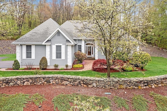 ranch-style home with a shingled roof and a front lawn