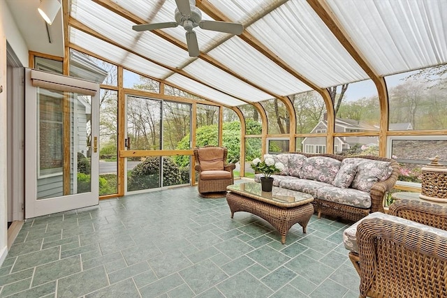 sunroom / solarium featuring a ceiling fan, lofted ceiling, and an outdoor living space