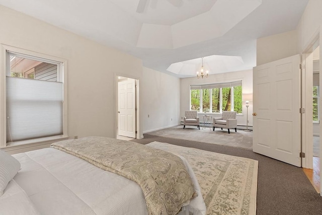carpeted bedroom with a chandelier, a tray ceiling, a ceiling fan, and baseboards