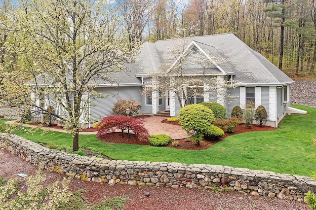 view of front of house with a front lawn and a shingled roof