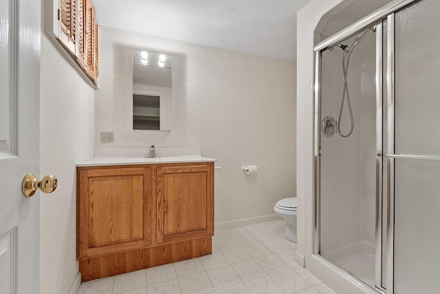 bathroom featuring toilet, a stall shower, vanity, and baseboards