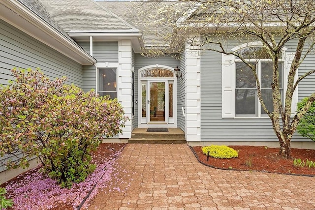 property entrance with a shingled roof