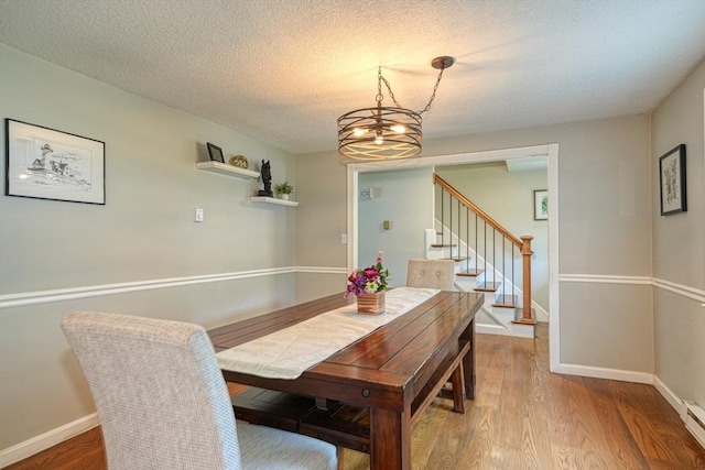 3 Alcorn Rd, Chelmsford, MA 01824 - dining room with a chandelier, stairway, wood finished floors, a baseboard heating unit, and a textured ceiling
