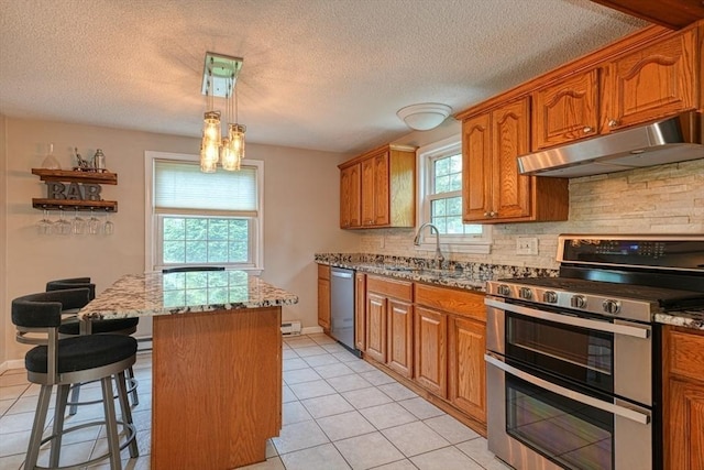 3 Alcorn Rd, Chelmsford, MA 01824 - kitchen with under cabinet range hood, appliances with stainless steel finishes, a sink, a kitchen island, and brown cabinetry