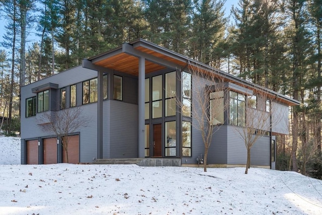 view of snow covered exterior featuring a garage