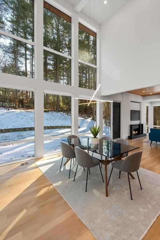 dining space featuring a towering ceiling and light hardwood / wood-style floors