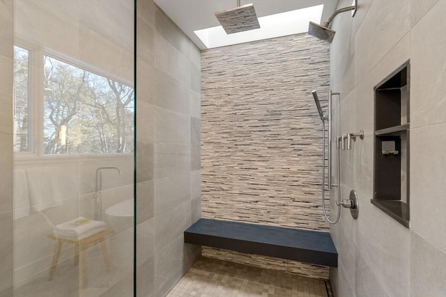 bathroom featuring tiled shower, tile patterned flooring, and tile walls