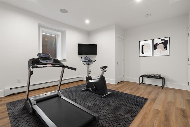 exercise room featuring a baseboard radiator and light hardwood / wood-style floors