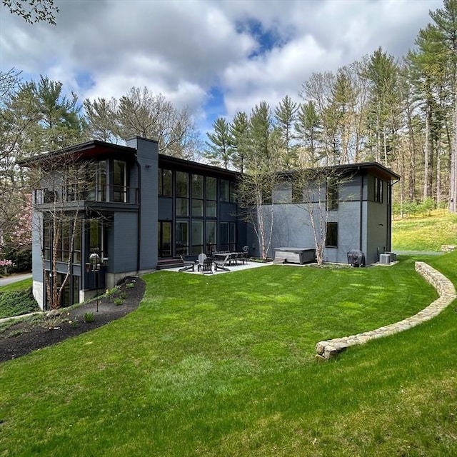 back of property featuring a patio and a lawn