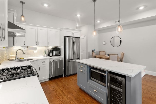 338 Meridian St Unit 2, Boston, MA 02128 - kitchen with appliances with stainless steel finishes, beverage cooler, wall chimney exhaust hood, white cabinetry, and recessed lighting