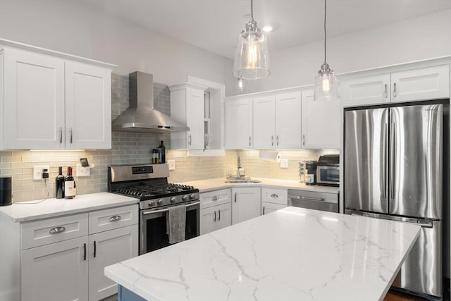 338 Meridian St Unit 2, Boston, MA 02128 - kitchen featuring appliances with stainless steel finishes, wall chimney range hood, white cabinetry, and a kitchen island