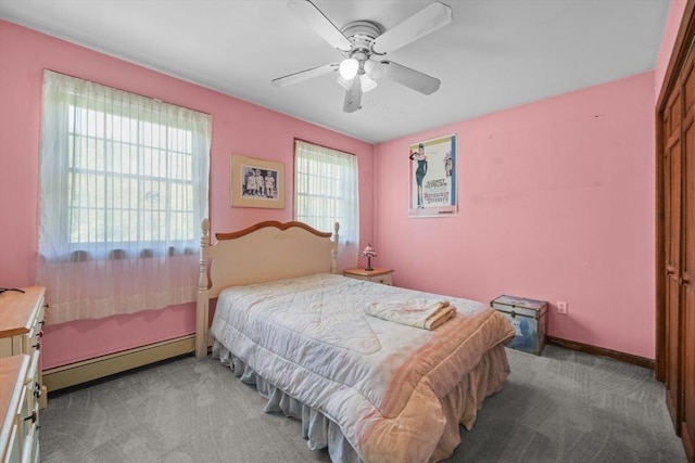 carpeted bedroom with ceiling fan and baseboard heating