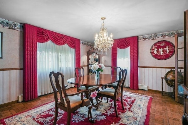 dining space with a chandelier, baseboard heating, and dark parquet floors