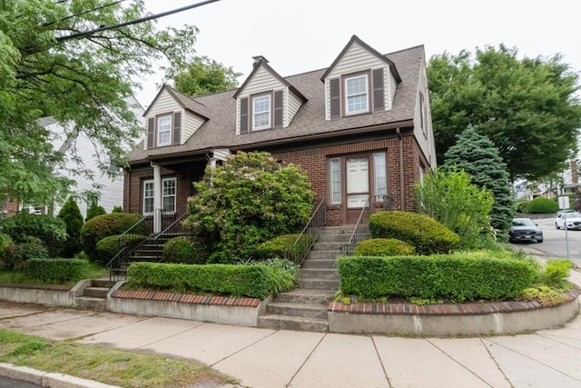 504 Mount Auburn St, Watertown, MA 02472 - cape cod house featuring brick siding, stairway, and a shingled roof