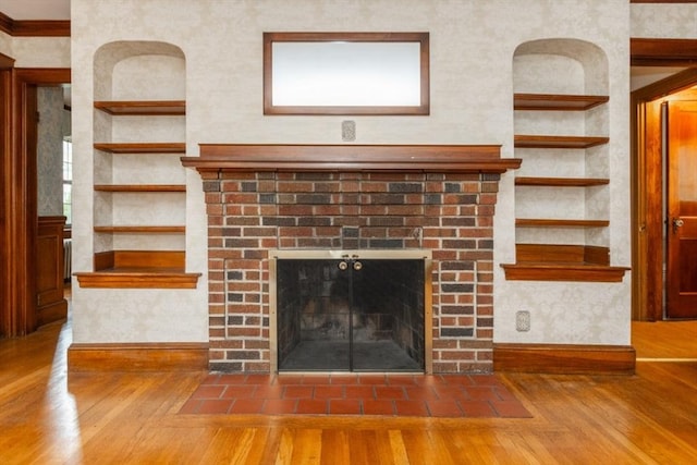 504 Mount Auburn St, Watertown, MA 02472 - detailed view of wood finished floors, a brick fireplace, built in shelves, and ornamental molding