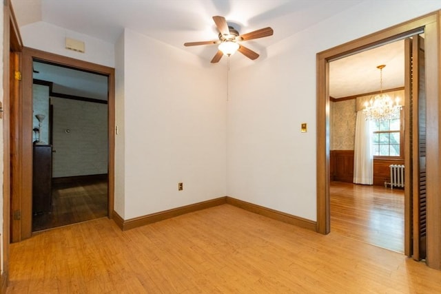 504 Mount Auburn St, Watertown, MA 02472 - empty room with radiator, light wood-style floors, a chandelier, a ceiling fan, and a wainscoted wall