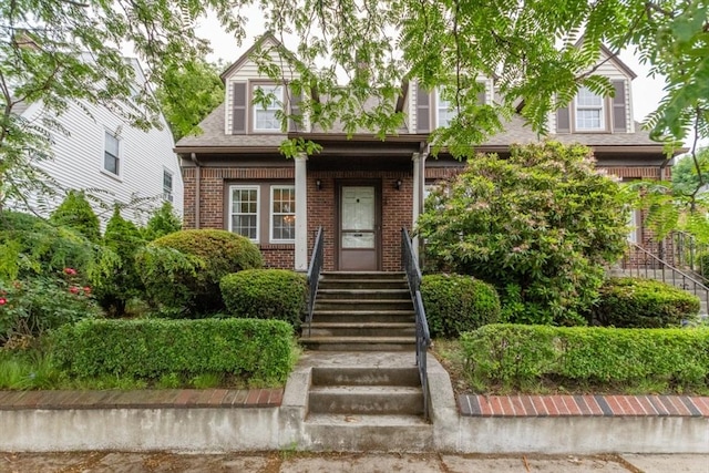 504 Mount Auburn St, Watertown, MA 02472 - cape cod house featuring brick siding, roof with shingles, and stairs