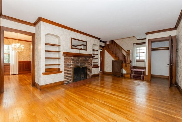 504 Mount Auburn St, Watertown, MA 02472 - unfurnished living room with light wood-style floors, a chandelier, ornamental molding, stairs, and wallpapered walls