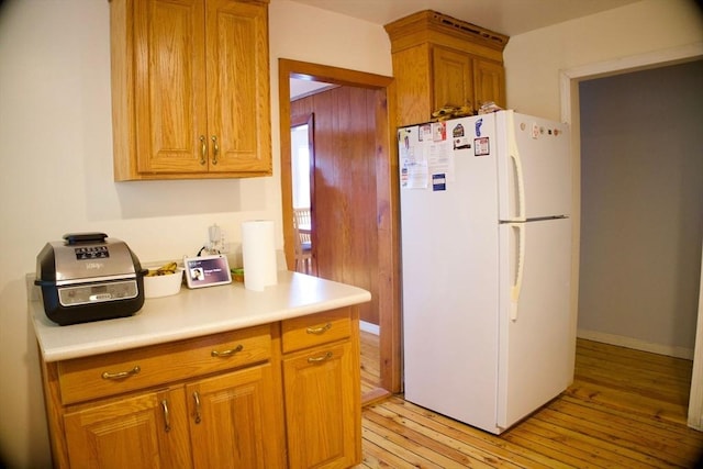 96 Harris St, Methuen, MA 01844 - kitchen featuring freestanding refrigerator, light wood finished floors, light countertops, and brown cabinetry