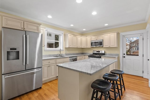 kitchen with a breakfast bar, a center island, light hardwood / wood-style flooring, appliances with stainless steel finishes, and light stone counters