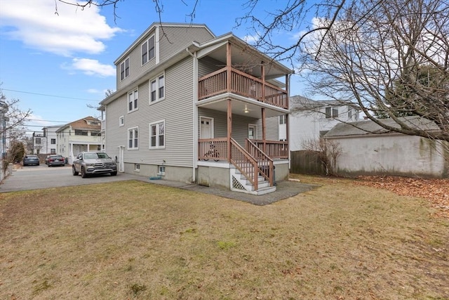 view of front of house featuring a balcony and a front yard