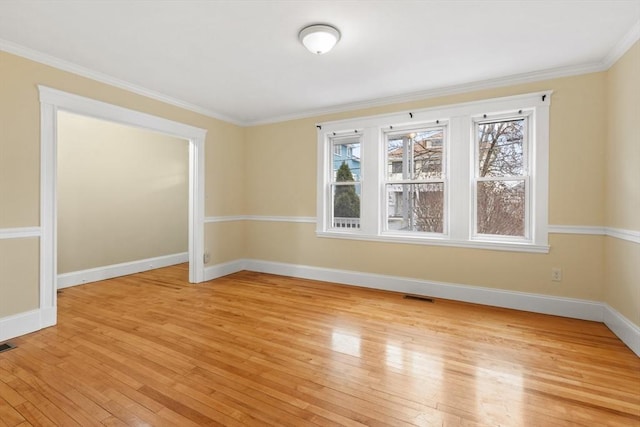 spare room with light wood-type flooring and ornamental molding