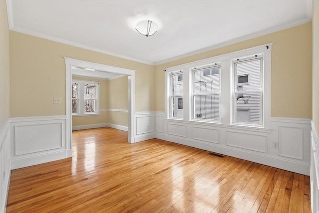 empty room with light hardwood / wood-style flooring and ornamental molding